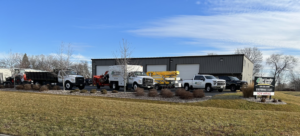 A fleet of tree service trucks and equipment parked outside Best Quality Tree Service in Oshkosh, WI.