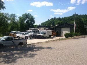 A fleet of Collins Tree Service, Inc. trucks and equipment parked outside their business location in Hooksett, NH.