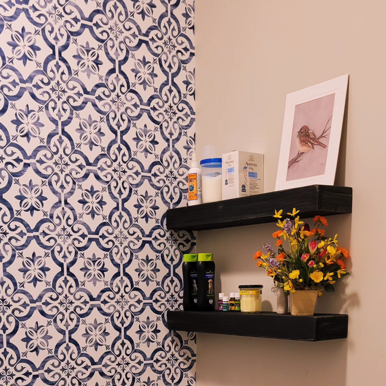Two black floating shelves installed on a decorative tiled wall, a service provided by NewRaj Home Improvement in Alexandria, VA.