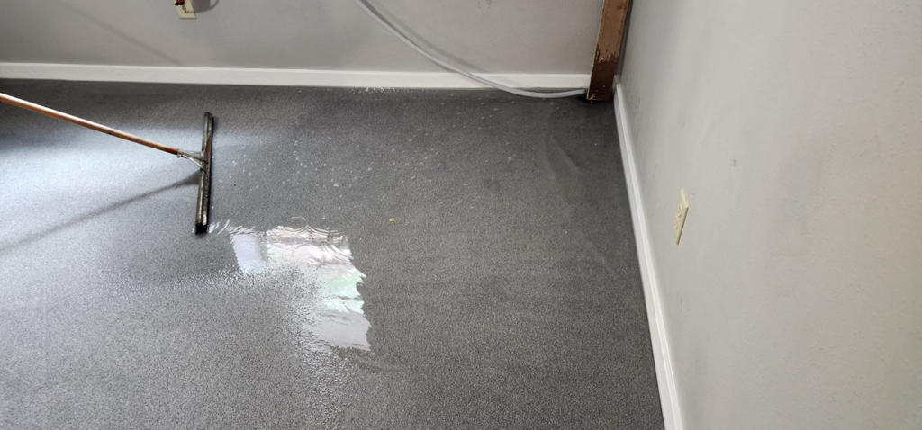 A professional applying a floor coating with a squeegee, a service offered by Get It Done in Sioux Falls, SD.