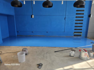 New blue floor coating being applied in a commercial space by Logical Drywall and Painting in St. Louis, MO.