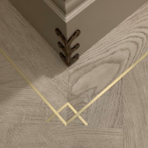 Close-up of new floor installation with decorative brass inlay by Jocia Construction Services in Gilbert, AZ.