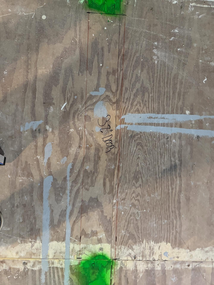 Close-up of a plywood subfloor with a '32" DOOR' marking, showing renovation layout planning by Shackelford Home Designs in Loveland, OH.