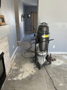 A floor being prepared for new installation with a large vacuum and sanding machine by Wam Bam Handyman LLC in Colorado Springs, CO
