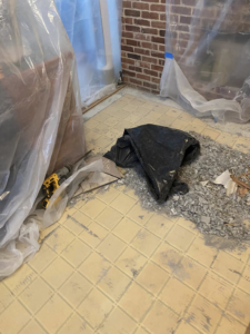 Floor tile removal in progress with debris and tools, handled by Main Street Handyman, LLC in Winter Garden, FL.