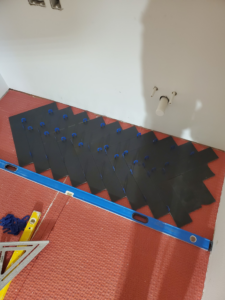 Floor tiling installation in progress with black tiles laid on underlayment by Tile Works inc in Naperville, IL.