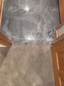 Floor transition between carpet and an epoxy-like floor by 5 Sons Plaster and Remodeling in Peoria, IL.
