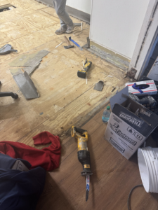 Flooring demolition with tools like a reciprocating saw and hammer during a handyman job by Floorboys LLC in Lexington, SC.