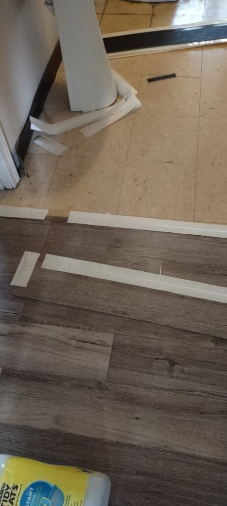 New flooring installation in progress, showing trim and old floor, by Handyashby in Saint Joseph, MO.