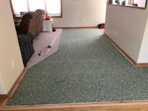 Flooring installation in progress, showing removed carpet and new underlayment by Honey Bee's Handyman Services in Hastings, NE.