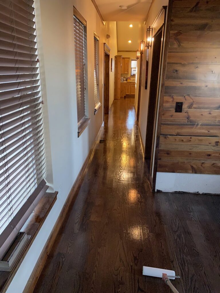 Flooring installation in progress, showing subfloor, new planks, and tools in a room by IHS flooring LLC in Brighton, CO.