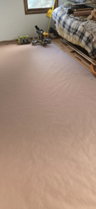 Flooring installation in progress with tools and protective covering by Schwoegler Remodeling in Madison, WI