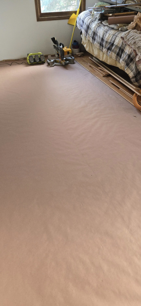 Flooring installation in progress with tools and protective covering by Schwoegler Remodeling in Madison, WI