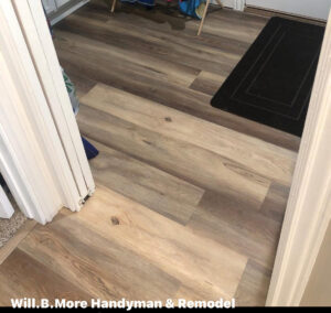 Flooring installation in progress, showing new planks being laid in a doorway by Will.B.More Handyman & Remodel in West Jordan, UT