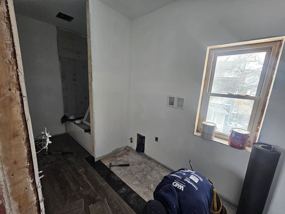 A worker installing new flooring in an interior room, demonstrating general contractor services by Done Well Home Improvement LLC in Buffalo, NY.