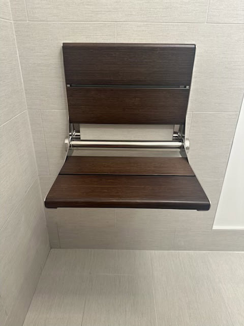 A convenient fold-down shower seat installed by Dynamic Design & Remodeling for accessibility in Westport, CT