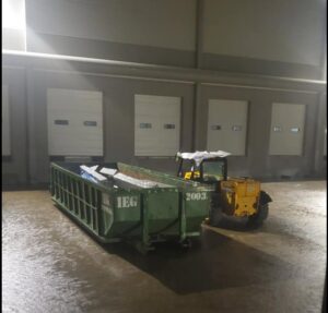 A forklift loading debris into an IEG Disposal roll-off dumpster at a commercial or industrial site in Canton, GA.