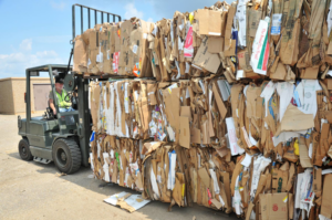 A worker operating a forklift to move baled cardboard at Nevada Recycling and Salvage in Reno, NV.
