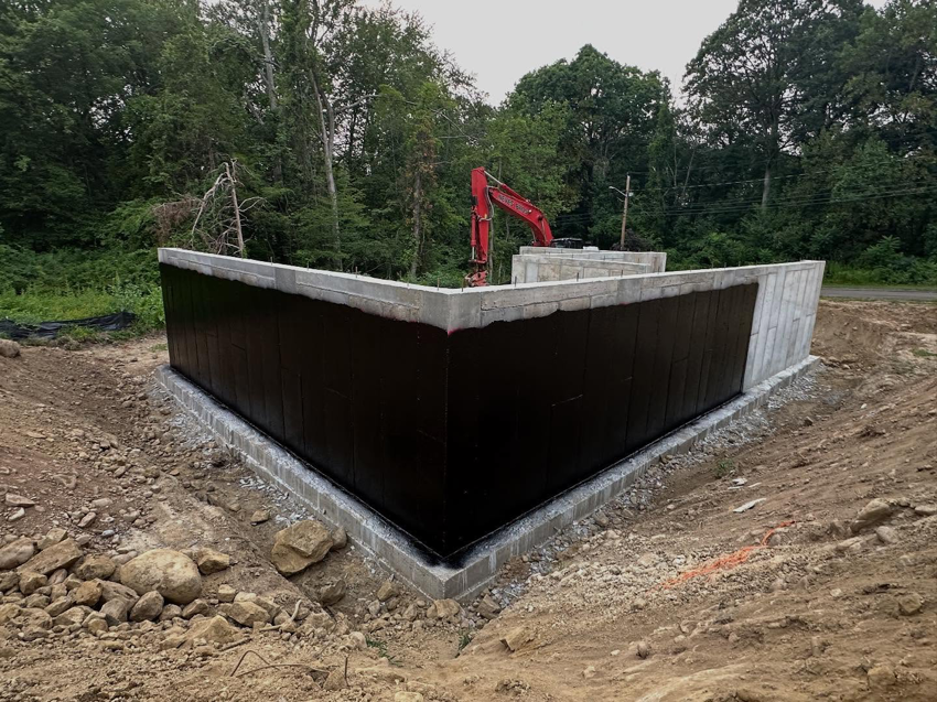 A foundation corner with black waterproofing membrane applied by ProSeal Waterproofing in Naugatuck, CT.