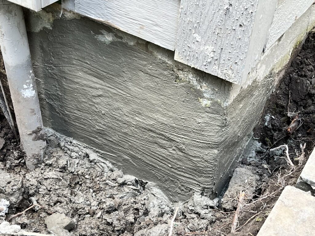 A foundation wall with fresh concrete repair work completed by Woodford Bros., Inc. in Apulia Station, NY