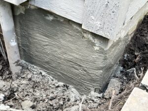 A foundation wall with fresh concrete repair work completed by Woodford Bros., Inc. in Apulia Station, NY