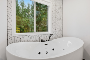 Modern freestanding bathtub with sleek black fixtures installed by BelRed Construction in Bellevue, WA.