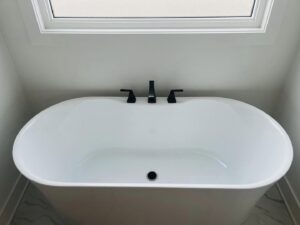 A modern freestanding bathtub with black faucets installed by Read Plumbing LLC in Ankeny, IA.