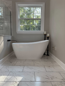 A newly installed freestanding bathtub and marble-look floor tiles by River Oak Renovations in Augusta, GA.