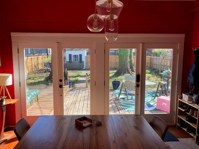 A dining room with newly installed French doors opening to a backyard deck by Custom Carpentry Service in Knoxville, TN.