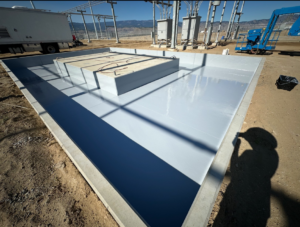 A large concrete containment area with a fresh, light grey coating applied by SlabJack Geotechnical in East Wenatchee, WA.