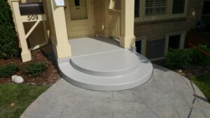 A freshly coated concrete porch and steps at a residential home, completed by ACT Restoration in Andover, MN.