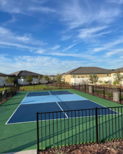 A freshly coated outdoor pickleball court with vibrant blue and green sections by Savage Coatings in Lakeland, FL.