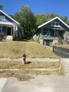 Two houses with freshly mowed lawns, showcasing professional landscaping services by Little Tykes Property Preservation in Independence, MO.