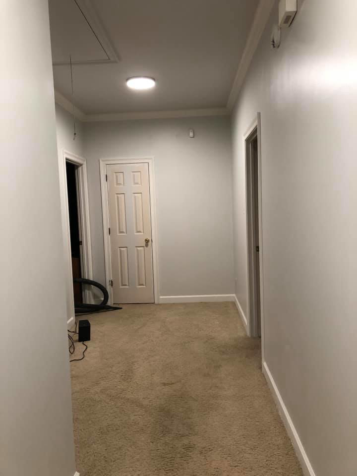 A freshly painted hallway with light gray walls and white trim, showcasing a completed project by Your Handy Helper in Mobile, AL