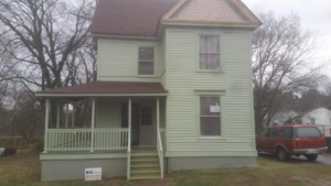 A freshly painted two-story house with a renovated front porch, completed by Big Idea Construction, LLC in Knoxville, TN.
