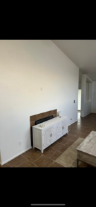 A freshly painted living room with a tiled fireplace and white walls by Arizona Contracting And Remodeling LLC in Tucson, AZ