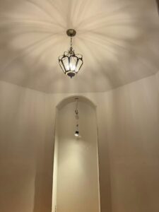 A freshly painted wall niche with a new light fixture installed by Tribute Painting & Drywall in St. Louis, MO.