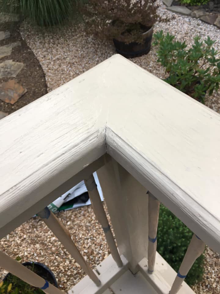 A close-up of a freshly painted outdoor deck railing, showcasing quality painting services by Calkins Cabinetry/Handyman's Services in Bentonville, AR.