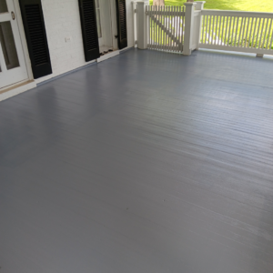A freshly painted outdoor porch with a grey floor and white railings by Carter's painting in Martinsburg, WV.