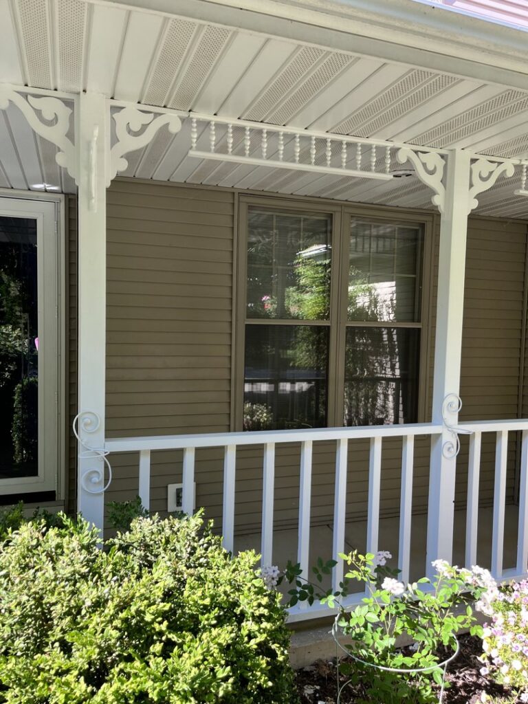 A freshly painted white porch and railings on a house exterior by Above & Beyond Painting, LLC in Green Bay, WI.