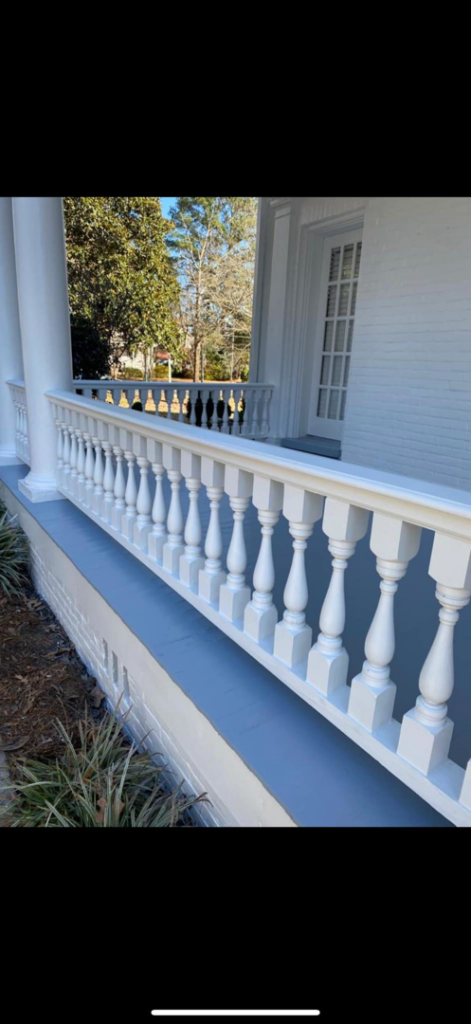 A freshly painted white porch railing and grey floor by Rodriguez Painting in Garner, NC