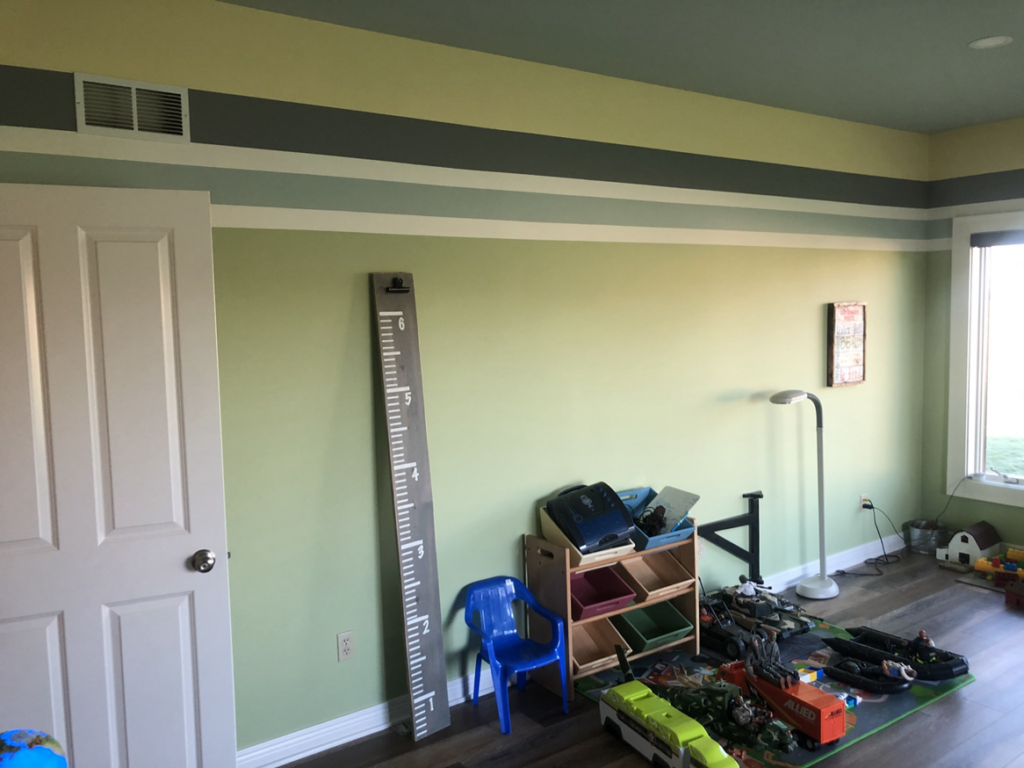 A freshly painted room with light green walls and decorative stripes by Grabill Painting and Drywall in Fort Wayne, IN.