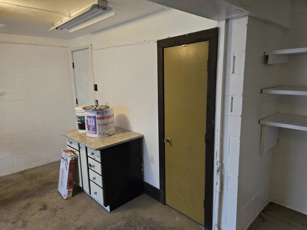 A freshly painted utility room with white cinder block walls and new shelves by Midwest Painting & Contracting in Powell, OH.