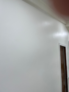 A close-up of a freshly painted white wall with new crown molding installed by Precision Home Improvement in Massapequa, NY.