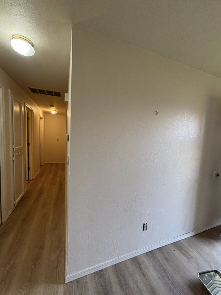 A freshly painted wall and hallway with new flooring, showcasing handyman work by Full Throttle Remodel in Salem, OR.