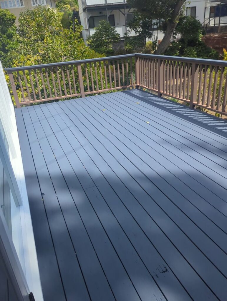 A freshly painted wooden deck with matching railings in a sleek dark grey, completed by Dan's Home and Yard in Oakland, CA.