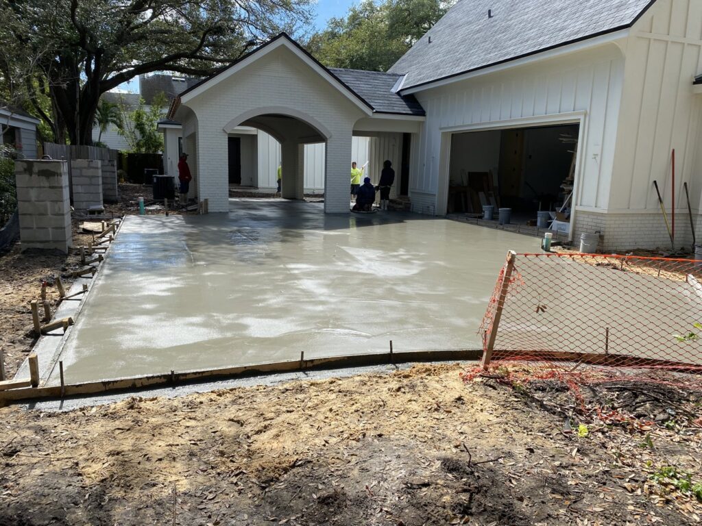 A freshly poured concrete driveway in front of a new residential home, a project by Bayside Concrete & Construction in Tampa, FL