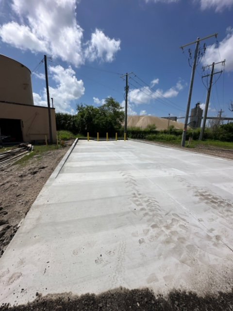 A freshly poured concrete pad or commercial driveway with tire tracks, completed by Bayside Concrete & Construction in Tampa, FL