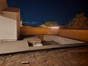 Freshly poured concrete pool deck and coping around an empty pool by Martin Jr's concrete in Surprise, AZ