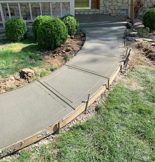 A freshly poured concrete sidewalk with wooden forms in place, installed by Complete Concrete of Indy, Inc. in Fishers, IN.